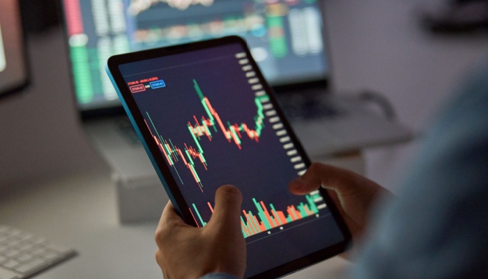 A person looking at a stock market graph on a tablet.