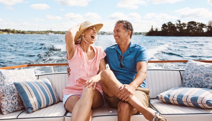 A couple in their 50s laughing on a boat together.